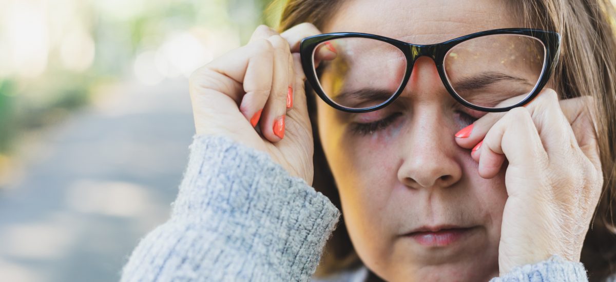 Žena v okuliaroch pretierajúca si oko