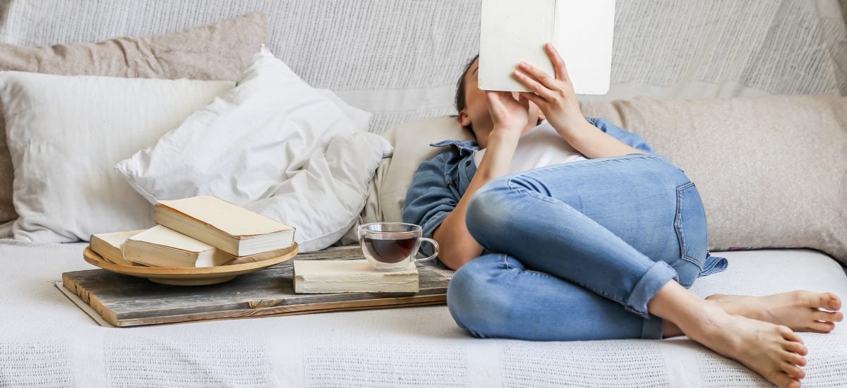 Žena číta knihu na posteli