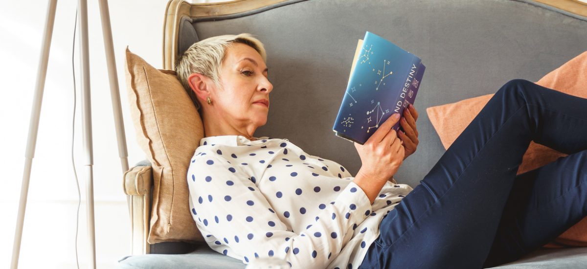 Žena čítajúca knihu na gauči