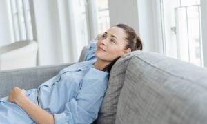 Mladá žena relaxuje na pohovke
