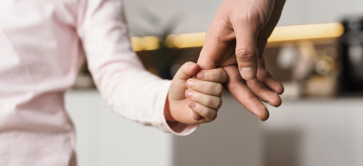 Dieťa drží za prst dospelého človeka