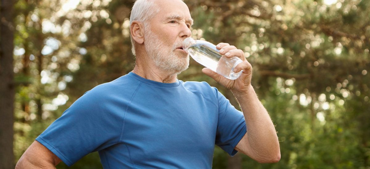 Starší pán pije vodu