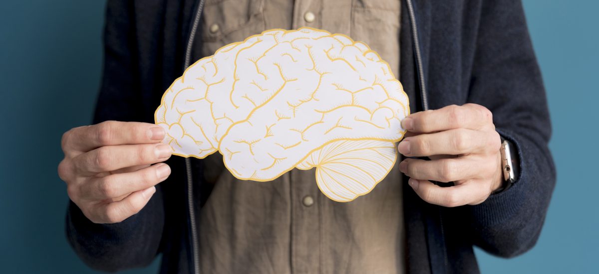 muž držiaci papierový obrázok mozgu
