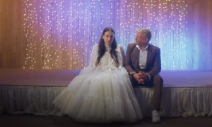 žena v svadobných šatách a starší muž v obleku, film Láska hory prenáša