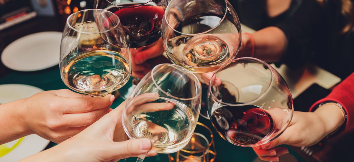 partia priateľov si pripíja s vínovými pohármi