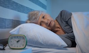 staršia žena seniorka, ktorá má problém so spánkom ; nespavosť