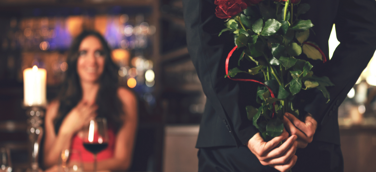 žena v reštaurácii čaká na muža, ktorý jej nesie ruže