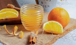 pomarančový sirup v nádobe a pomaranče