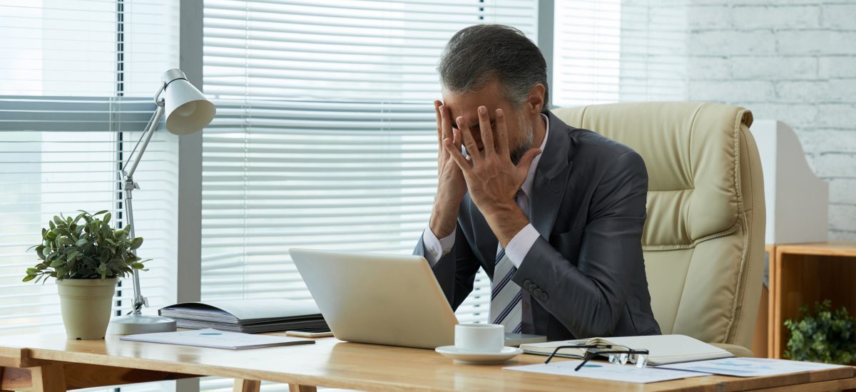 muž v strednom veku je v práci pod stresom