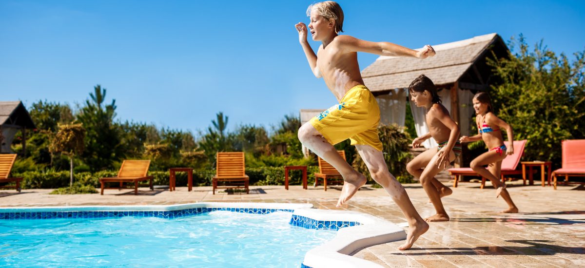 deti skákajúce do bazéna