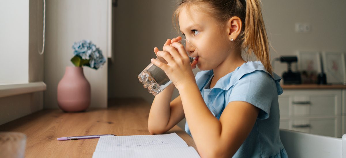 malé dievča pije vodu z pohára