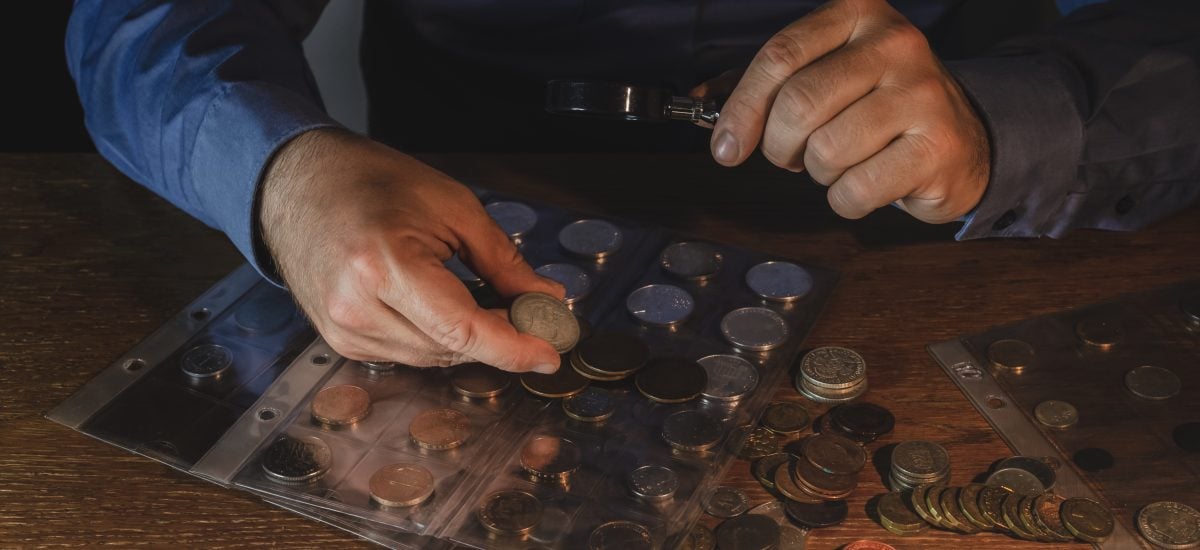 Muž si prezerá zbierku mincí