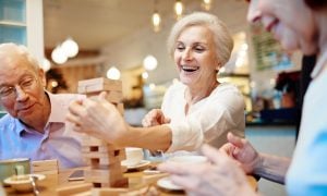 dôchodcovia hrajúci spoločenskú hru Jenga