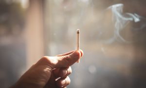 muž držiaci cigaretu