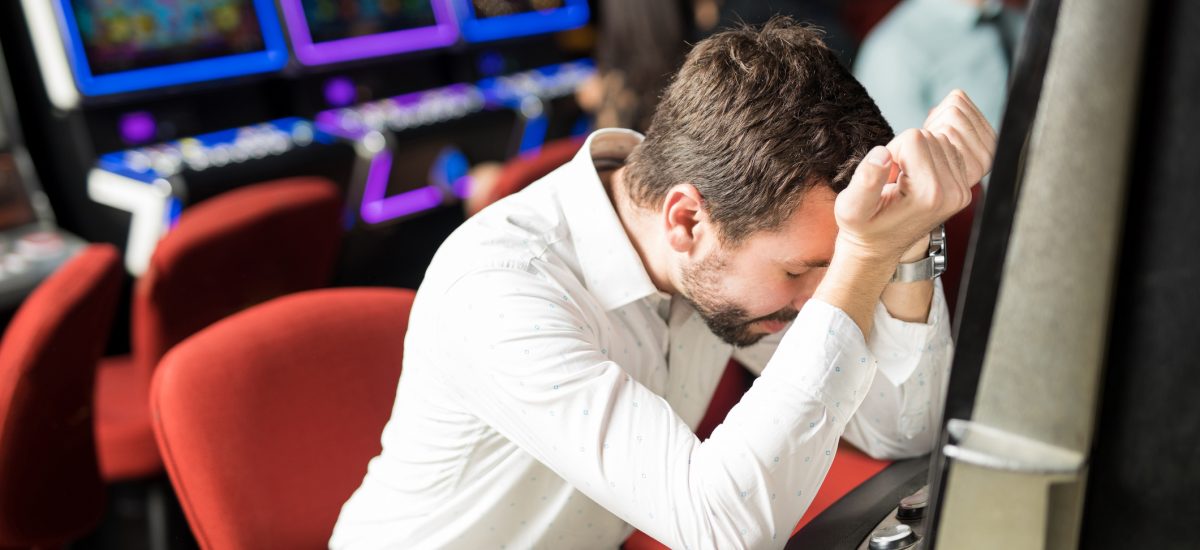 nešťastný muž sa drží za hlavu v kasíne