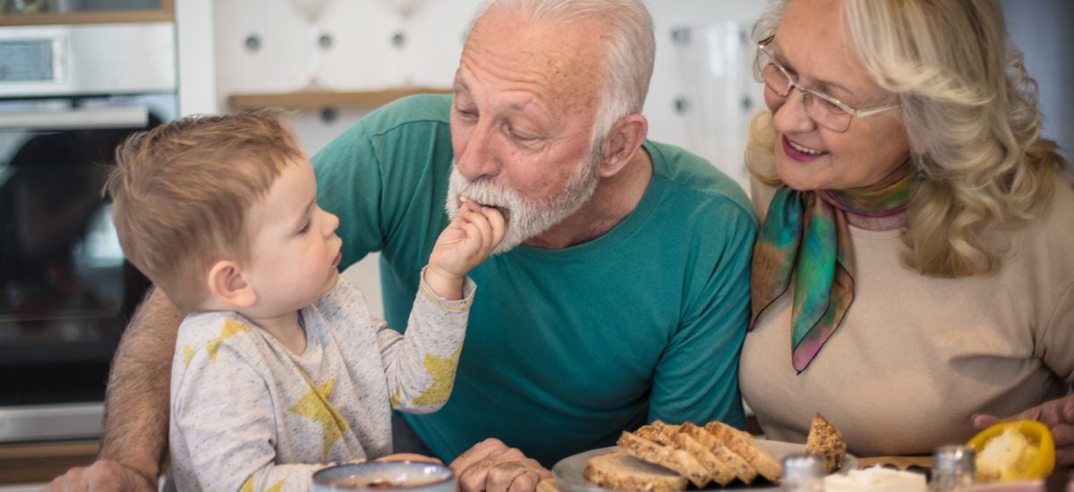 starí rodičia s vnúčikom jedia chlieb