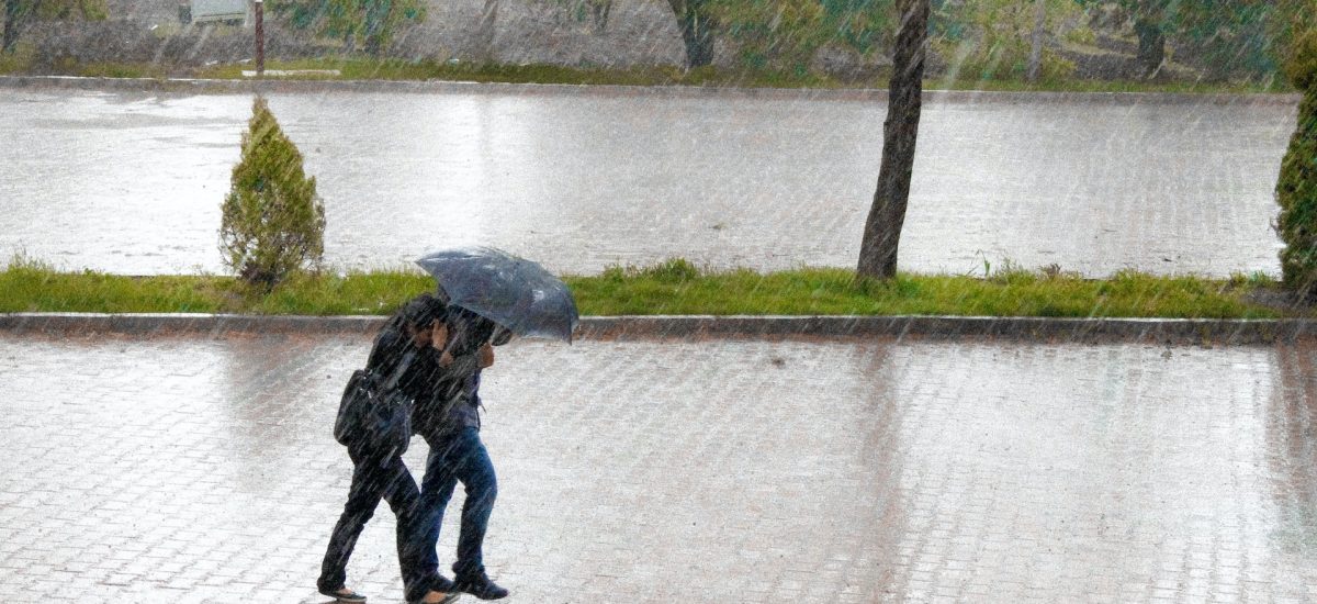 extrémne zrážky a ľudia kráčajú pod dáždnikom