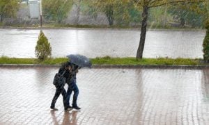 extrémne zrážky a ľudia kráčajú pod dáždnikom