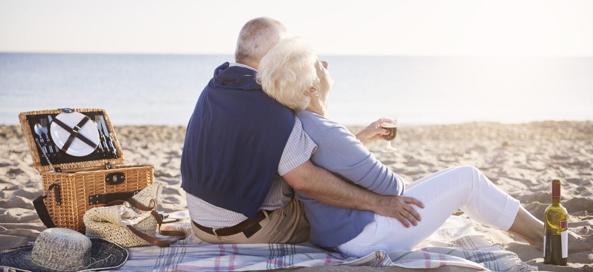 starší pár oddychuje na pláži