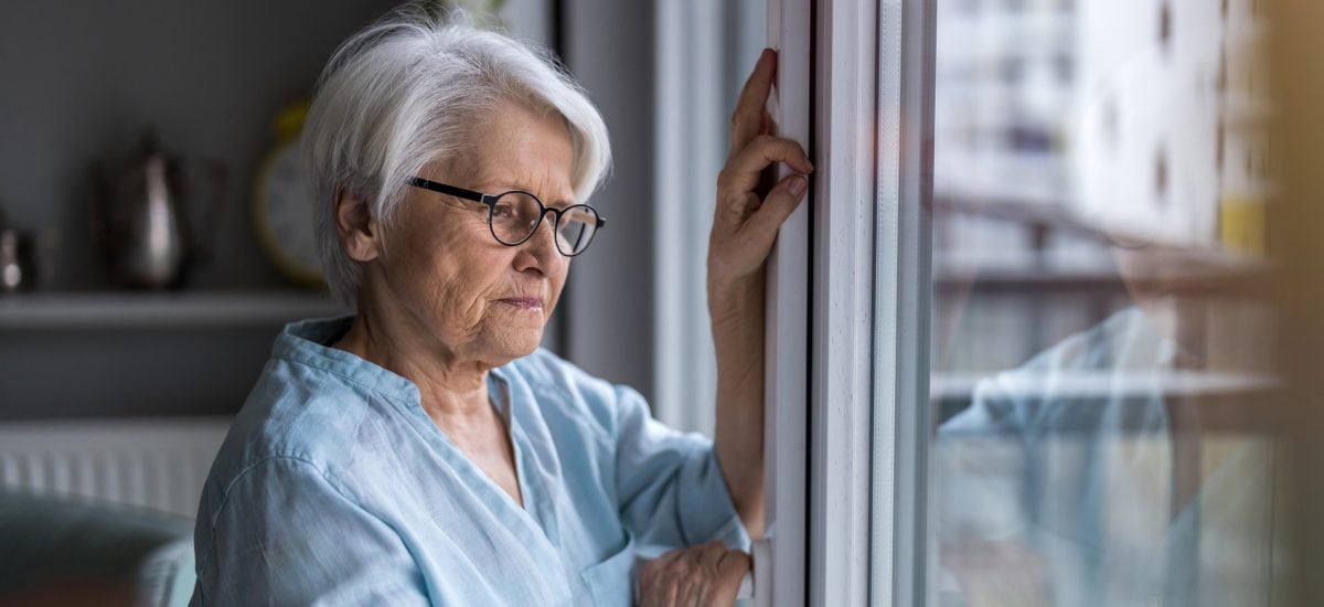 staršia žena pozerá z okna