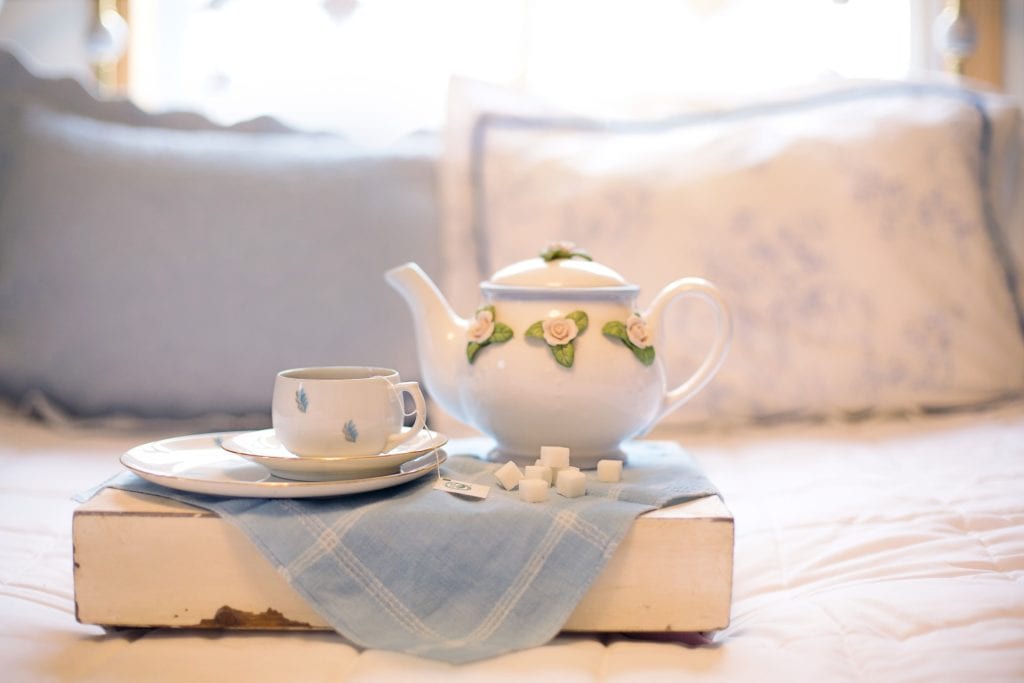 šálka čaju a čajník na podnose