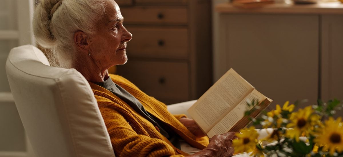 staršia žena si číta knihu