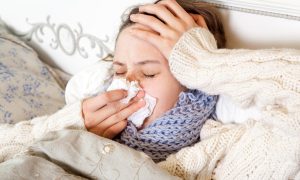 chorá žena leží v posteli a užíva antibiotiká