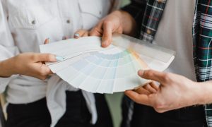 muž a žena držia paletu odtieňov, na ktorej je farba roka 2026